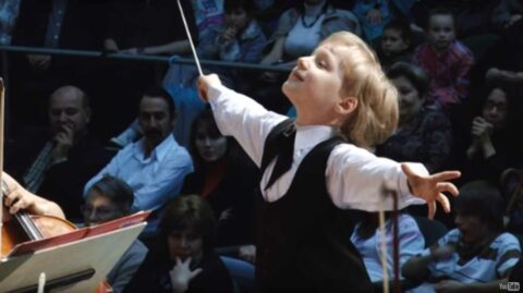 Маленькая девочка дирижирует оркестром